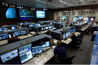 Photo of mission-control operators used as an analogy for control logic that directs datapath actions.