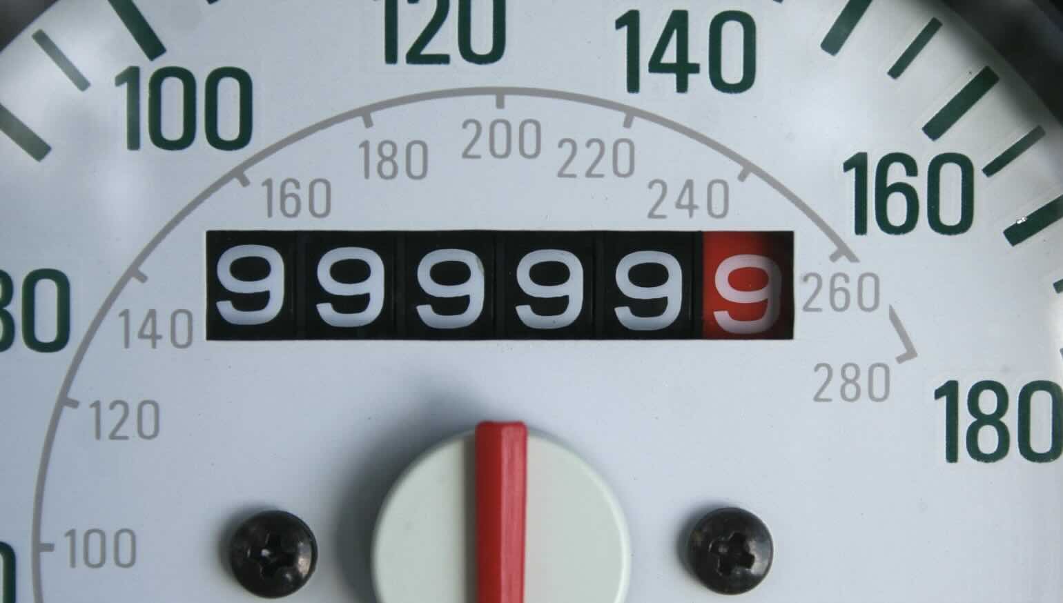 Close-up photograph of a mechanical car odometer showing the reading 999999 just before it rolls over. The image illustrates a finite counting device that will wrap back to 000000 after one more tick.